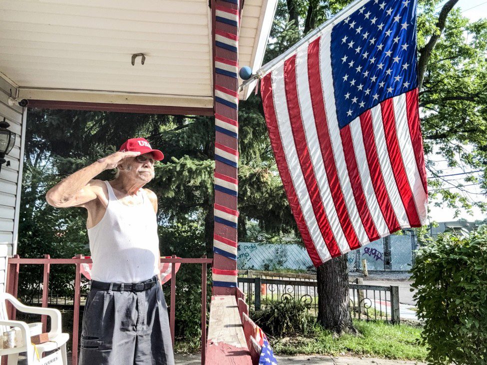 Slavic Villager Jerry Konopka salutes the flag from his porch on Independence Day 2026.